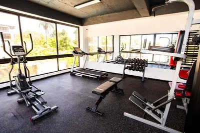 a gym with several treadmills and machines in a room at Luxury Beachside Escape 3BR 2BA with Pool & Ocean Views in San Felipe de Puerto Plata