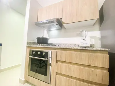a kitchen with wooden cabinets and a stove top oven at Livera park in Santiago de los Caballeros