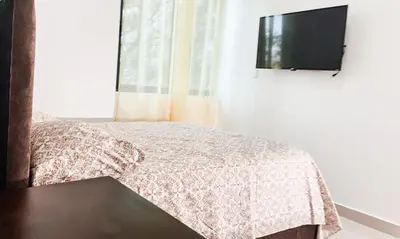 a bedroom with a bed and a flat screen tv at Livera park in Santiago de los Caballeros