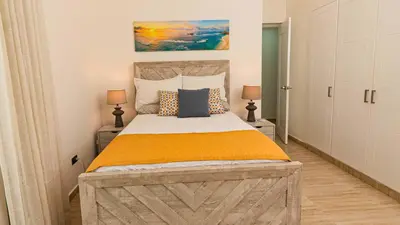 a bedroom with a large bed and two lamps at Maple Beach Residences Punta Cana in Punta Cana
