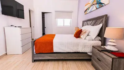 a bedroom with a bed and a dresser and a television at Maple Beach Residences Punta Cana in Punta Cana