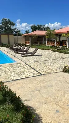 a row of benches sitting next to a swimming pool at Villa La Perla in Pimentel