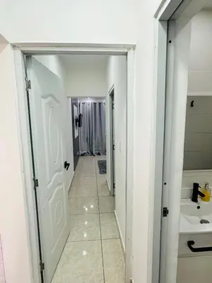 a hallway of a bathroom with a sink and a mirror at Apartamento en la romana residencial los García I in La Romana