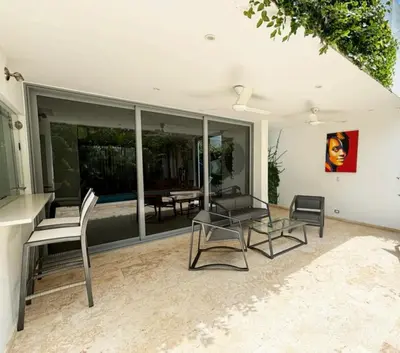 a living room with chairs and a glass table at Tropical VILLAGE in Las Terrenas