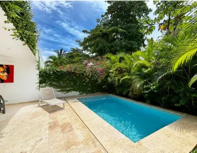 a white chair sitting next to a swimming pool at Tropical VILLAGE in Las Terrenas