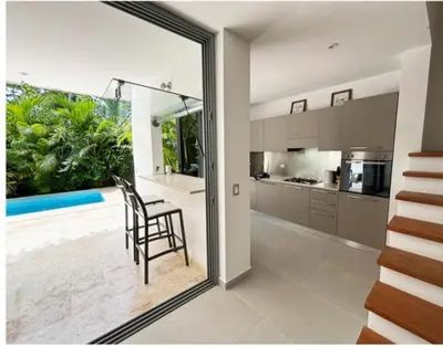 a kitchen with a table and a chair in a room at Tropical VILLAGE in Las Terrenas