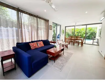 a living room with a blue couch and a table at Tropical VILLAGE in Las Terrenas