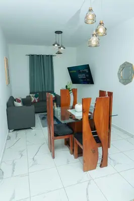 a dining table and chairs in a living room at Ventura Living in Nagua