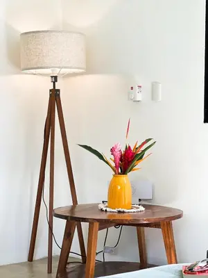 a table with a lamp and a vase with flowers at Jungle Tiny House in El Valle