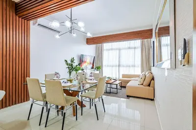 a dining room and living room with a table and chairs at Comfy 2BR Condo, Roof Top Pool. in Santo Domingo