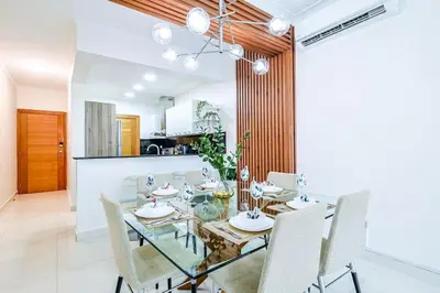 a dining room with a glass table and chairs at Comfy 2BR Condo, Roof Top Pool. in Santo Domingo