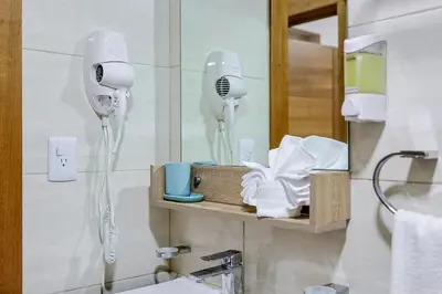 a bathroom with two hair dryers and a mirror at Comfy 2BR Condo, Roof Top Pool. in Santo Domingo