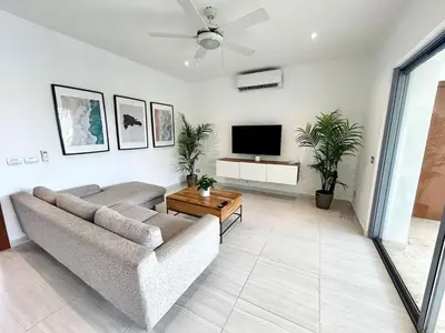 a living room with a couch and a flat screen tv at Modern 2BD With Pool And Huge Private Terrace in Las Terrenas