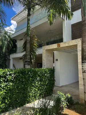 a building with a white garage and palm trees at Modern 2BD With Pool And Huge Private Terrace in Las Terrenas
