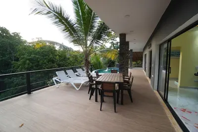 a patio with a table and chairs on a balcony at Villa Palacio Verde in Las Terrenas