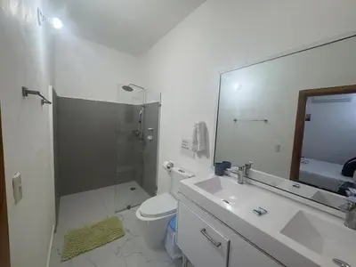 a bathroom with a sink and a toilet and a mirror at Villa Palacio Verde in Las Terrenas