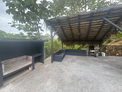 a patio with a wooden roof and a bench at Villa Palacio Verde in Las Terrenas