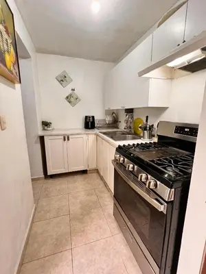 a kitchen with a stove top oven in a room at Alojamiento cerca de Agora y Blue Mall y Cine etc in Santo Domingo