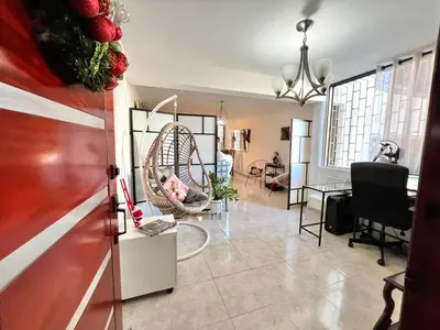 a living room with a table and a swing at Alojamiento cerca de Agora y Blue Mall y Cine etc in Santo Domingo