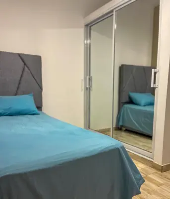 a bedroom with a blue bed and a mirror at Ocean Vibes - Bayahibe in Bayahibe