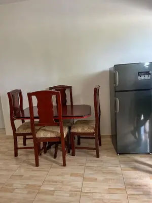 a dining room with a table and chairs and a refrigerator at Ocean Vibes - Bayahibe in Bayahibe
