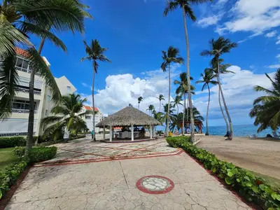 a building on the beach with palm trees at Apartamento frente al mar en Albatros in Villas del Mar