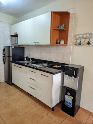 a kitchen with white cabinets and a black counter top at Apartamento frente al mar en Albatros in Villas del Mar