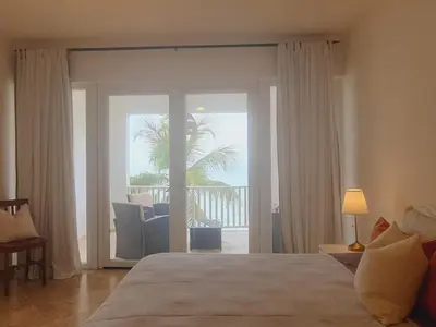 a bedroom with a bed and a sliding glass door at Cabarete Beach Palace 3-BDR Condo in Cabarete