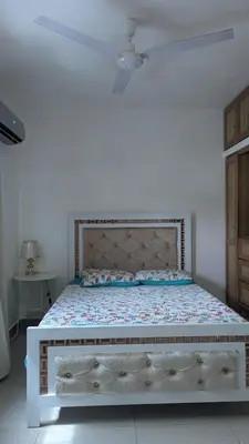 a bed in a white room with a white ceiling at Mitaly apartamentos RD H in Santo Domingo