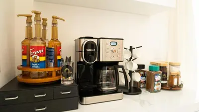 a counter with a coffee maker and bottles of alcohol at Luxurious PH, Near Airport,Private Jacuzzi in Santiago de los Caballeros