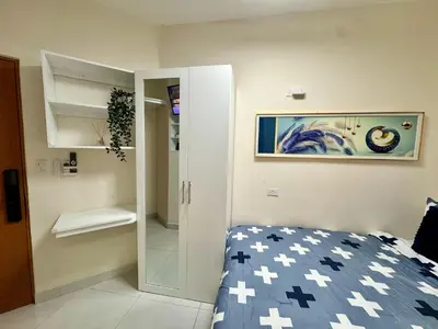 a small bedroom with a bed and a mirror at Affordable room near the beach in San Felipe de Puerto Plata