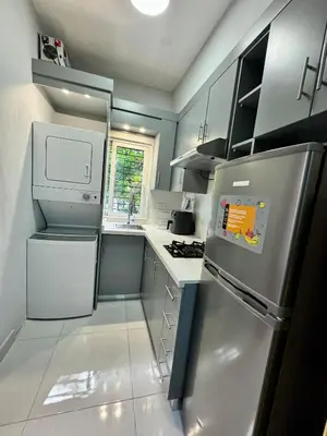 a small kitchen with a refrigerator and a stove at Affordable room near the beach in San Felipe de Puerto Plata