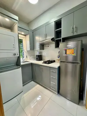 a kitchen with stainless steel appliances and gray cabinets at Affordable room near the beach in San Felipe de Puerto Plata