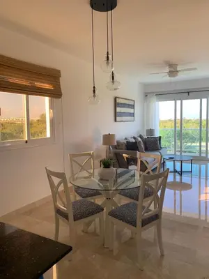 a living room with a glass table and chairs at Casual and comfort condo at Cana Rock Condos in Punta Cana