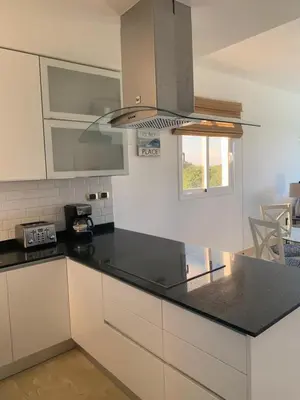 a kitchen with a black counter top and white cabinets at Casual and comfort condo at Cana Rock Condos in Punta Cana