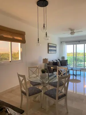 a living room with a glass table and chairs at Casual and comfort condo at Cana Rock Condos in Punta Cana