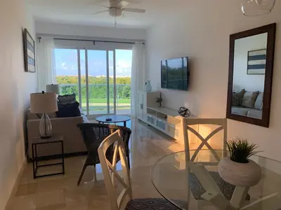 a living room with a glass table and a couch at Casual and comfort condo at Cana Rock Condos in Punta Cana