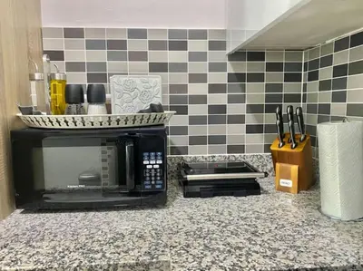 a kitchen counter with a microwave and a counter top withtools at Cozy, City Center Condo in Santo Domingo