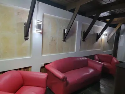 a waiting room with two red chairs and posters at Apartamento Minimalista in Santiago de los Caballeros