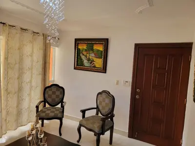 two chairs in a living room with a chandelier at Apartamento Minimalista in Santiago de los Caballeros
