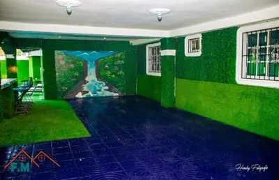 a room with a green wall with a painting of a clock at Villa en Pedernales in Pedernales