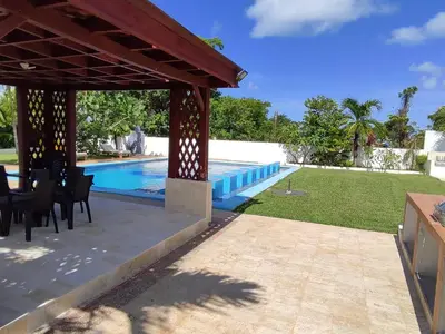 a patio with a table and chairs next to a swimming pool at Natural Pool Villa perfect for families in Río San Juan