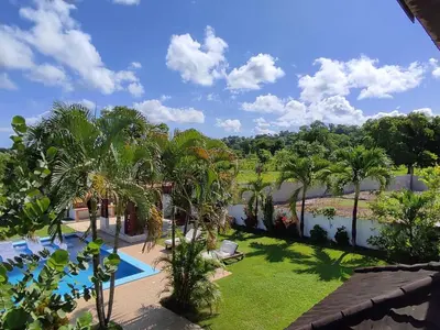 a view of a resort with a pool and palm trees at Natural Pool Villa perfect for families in Río San Juan