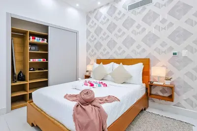 a bedroom with a white bed with a pink scarf on it at Upscale Condo, Spectacular Views in Santo Domingo
