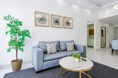 a living room with a blue couch and a table at Upscale Condo, Spectacular Views in Santo Domingo