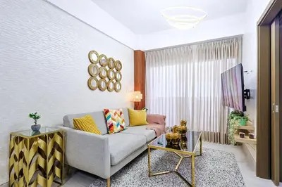 a living room with a couch and a table at Comfy 1BR Apt, King Bed, Pool in Santo Domingo
