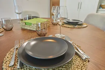 a table with a plate and wine glasses on it at Modern Escape with Pool & Beach in Puerto Plata