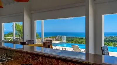 a dining room with a view of the ocean at Casa Las Piedras in Las Terrenas