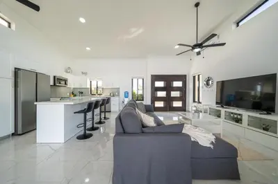 a living room with a couch and a kitchen at Luxury Villa, Pool & Prime Location in Sosúa