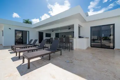 a patio with chairs and tables in a building at Luxury Villa, Pool & Prime Location in Sosúa